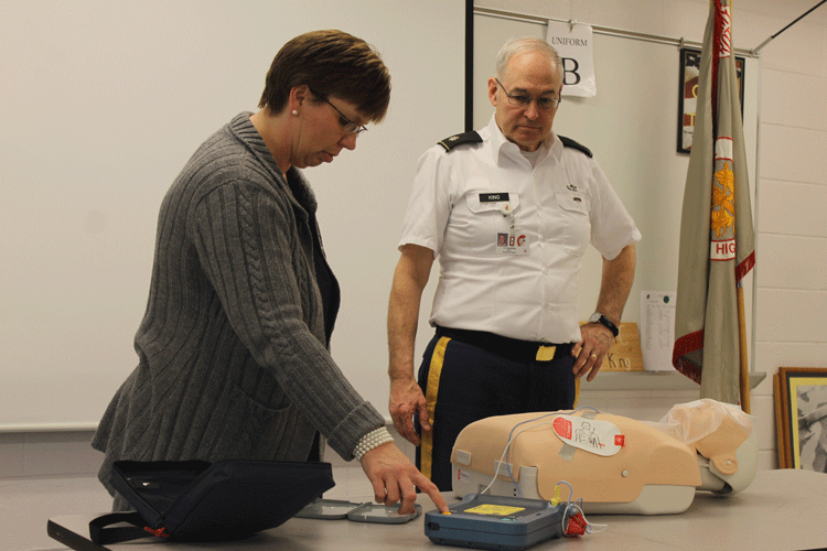 Colonel King instructs Mrs. Aherron on the techniques of CPR.