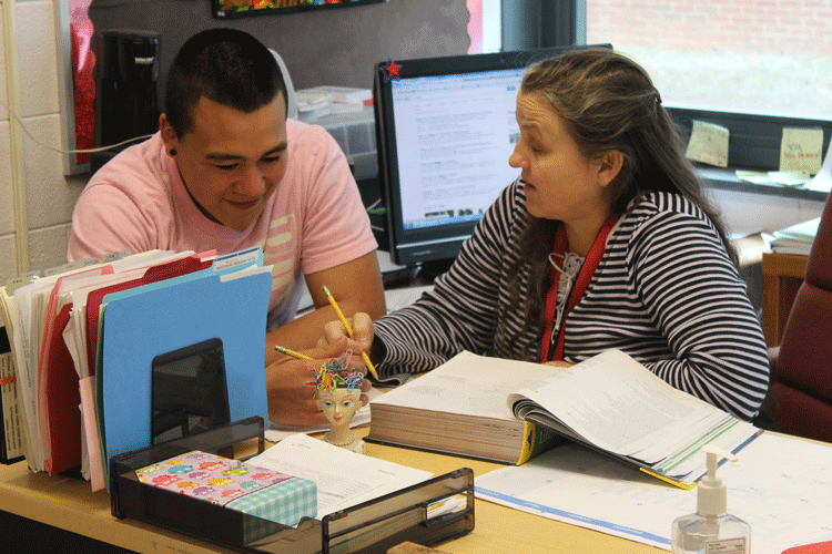Mrs. Hendrix helps one of her students, Alonso Escalante.