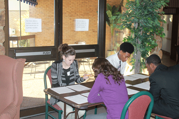 Demi Mills, TeAun Carter, and Damarcus Whimbush read their prompts before  roleplay interviews. 