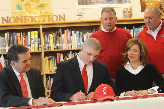 Senior Caleb Ashworth, signs his letter of intent with the Cincinatti Bearcats as his parents and Head Coach Buddy Brown look on. 