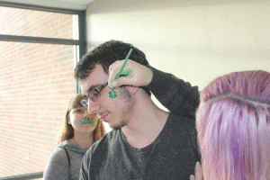 Senior Ray Williams gets his face painted for St. Patty's day