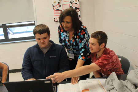 Mrs. Goard instructs Jeremy Wyatt and Matthew Compton during a marketing class. 