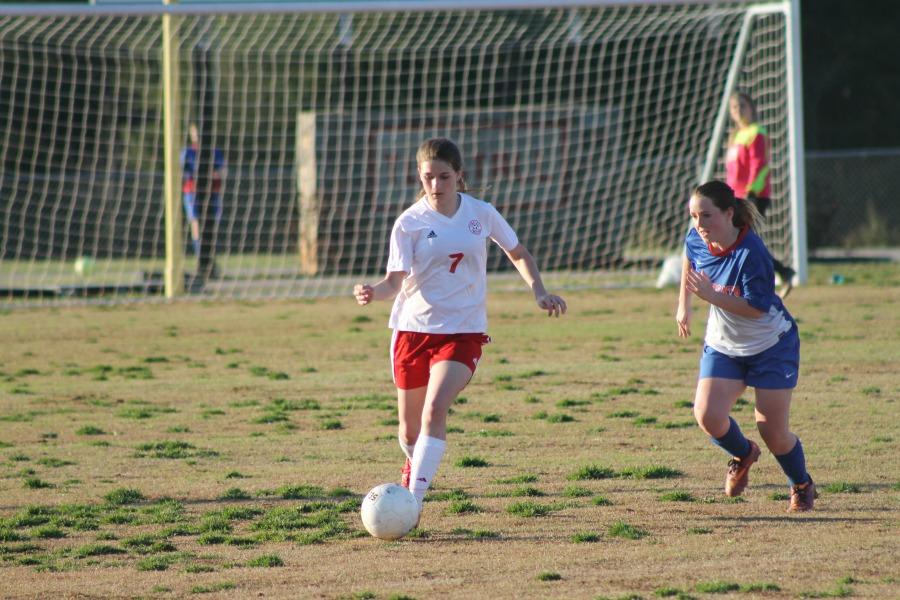 Lexi Toufas, sophomore, dribbles by Wildcat attacker. 