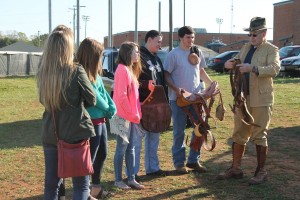 Students listen as Colonel King explains horse saddle equipment.