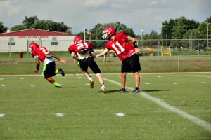 Starting quarterback Luke Buckner hands off the ball to running back Michael Pyrtle.