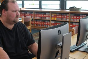 Bobby Clowers working hard to fix a computer in the library. 