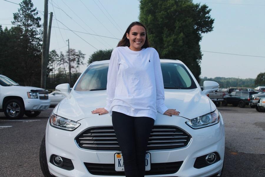 Kasey Marshall poses in front of her shiny Ford Focus. 