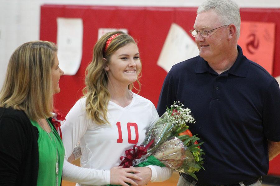 After shaking her coachs and principals hands, Abby Scarce stands with her parents as she is recognized.