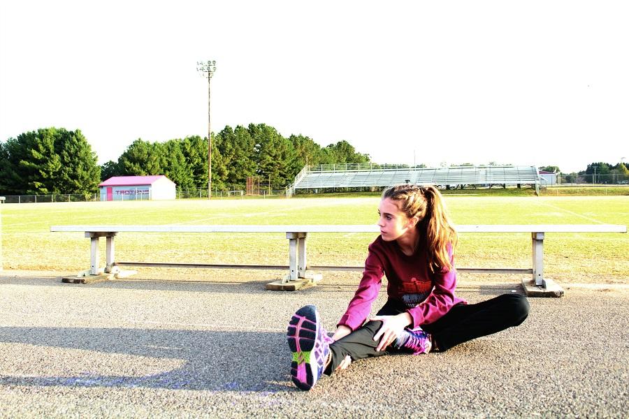 Emily prepares to run, but not before doing her stretching 