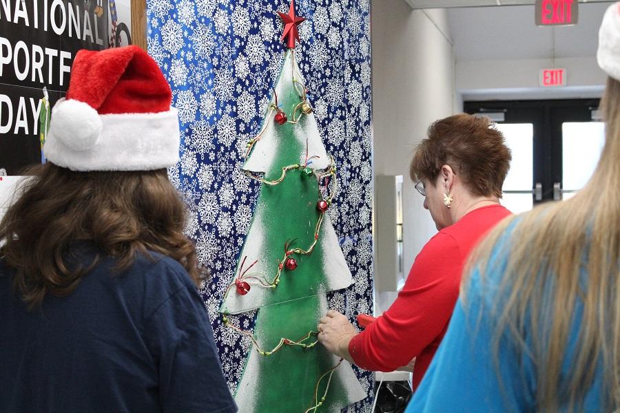 Mrs. Evans and few art students decorate their door for Deck the Halls.