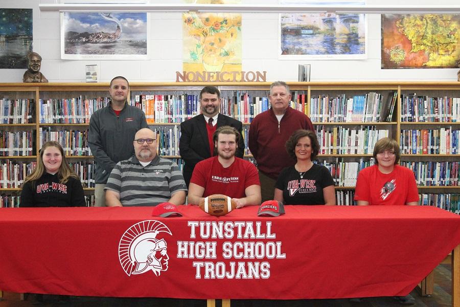 McBride signs his Letter of Intent to play college football this upcoming fall with family, coaches, and Principal Bowles supporting him