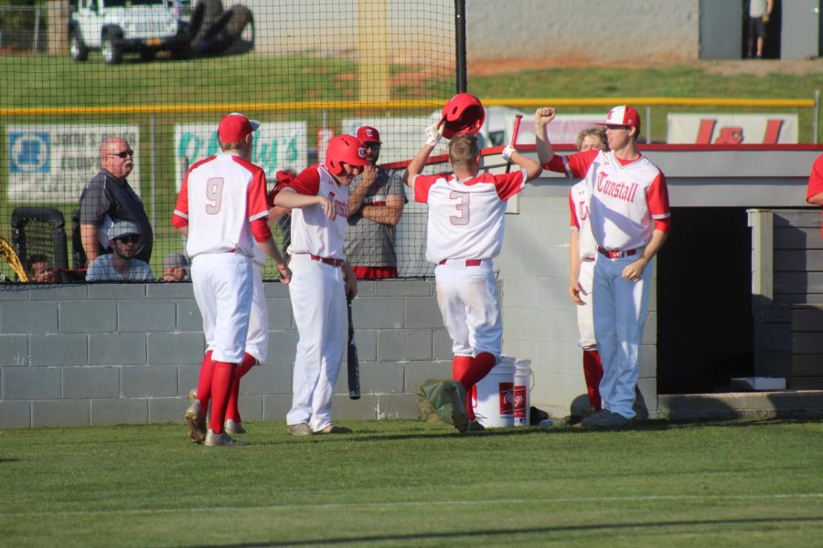 The Trojan Pack celebrates after bringing in two runs. 