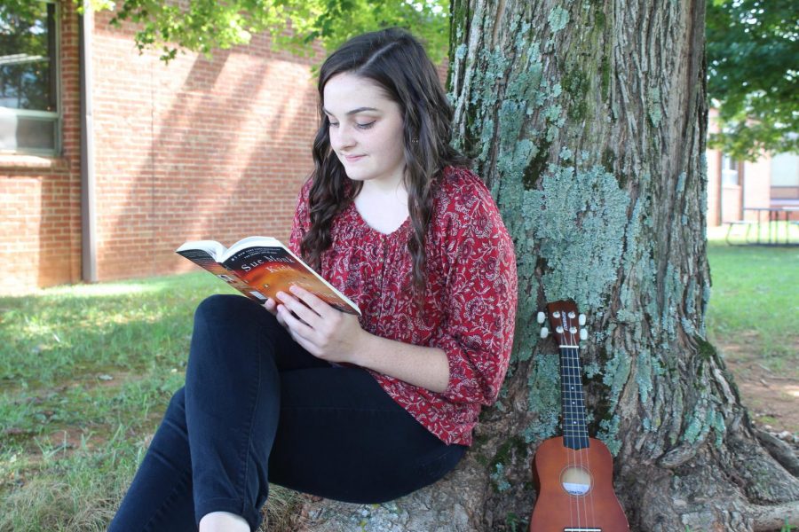 Kacey taking a break from school and reading outside