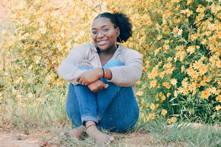 Senior Alexandria Woods posing for her senior pictures in a field.