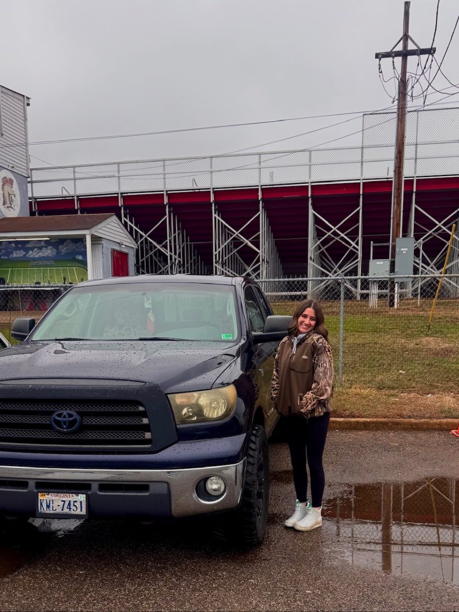 Junior Sarah Payne posing next to her truck