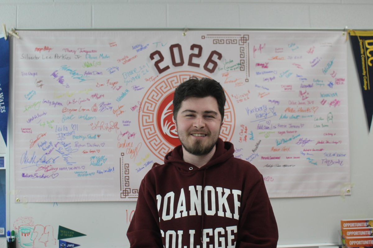 Mr. Jack posing in front of his banner that all of the seniors signed. 